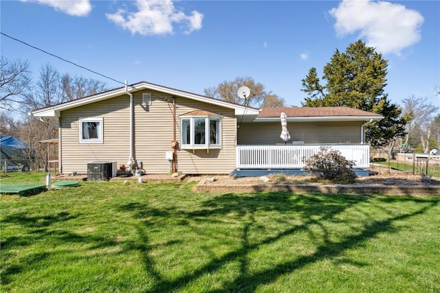 back of house featuring central AC and a lawn