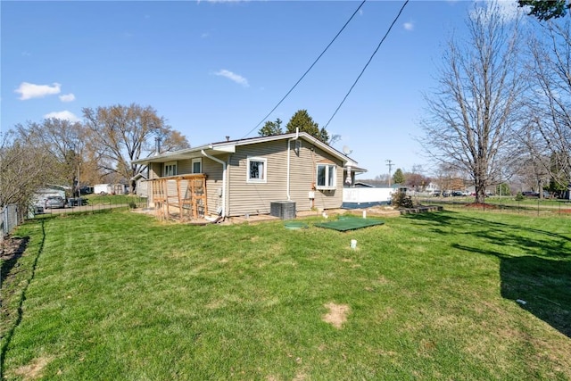 view of side of home with a yard, central AC, and fence
