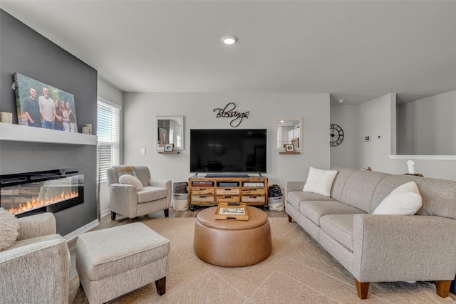 living area with recessed lighting and a glass covered fireplace