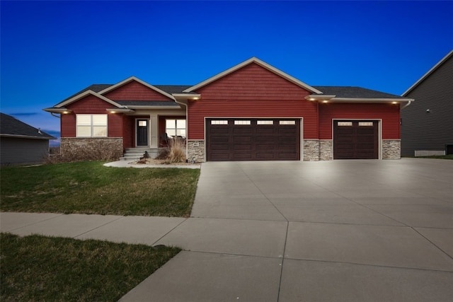 craftsman house with concrete driveway, a front yard, an attached garage, and stone siding