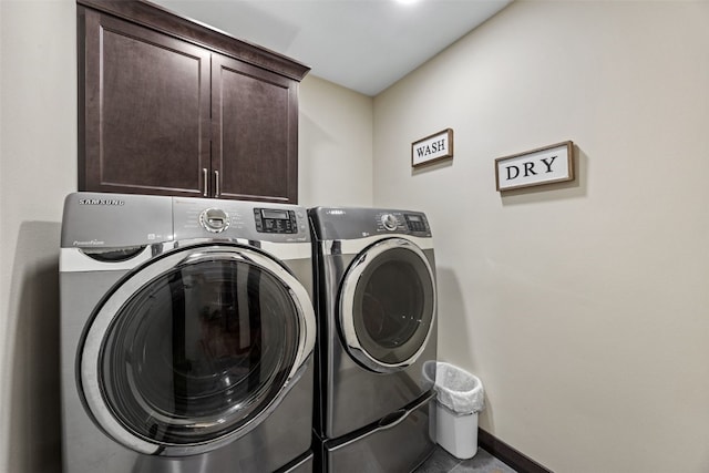 clothes washing area with cabinet space, washing machine and clothes dryer, and baseboards