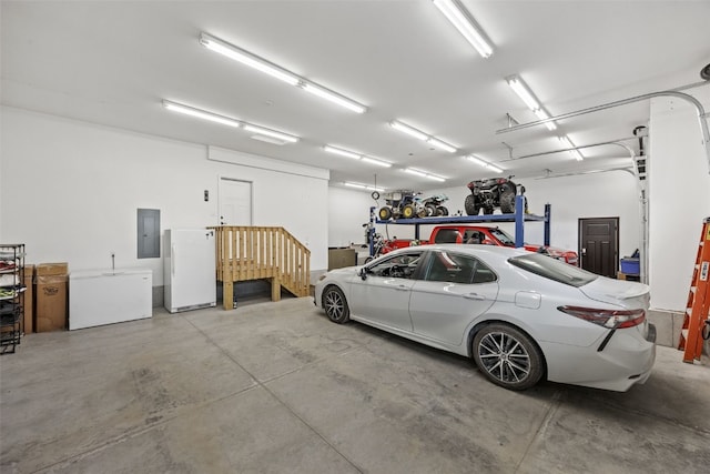garage with electric panel, white fridge, and freestanding refrigerator