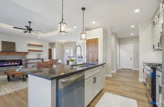 kitchen with dark countertops, a sink, white cabinets, and stainless steel appliances