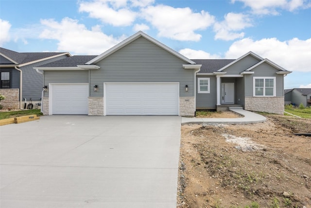1442 Cardinal Dr, Fairfax, IA 52228 - view of front of home with stone siding, a garage, driveway, and roof with shingles
