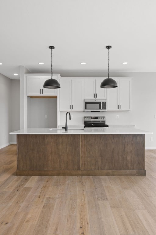 1442 Cardinal Dr, Fairfax, IA 52228 - kitchen featuring stainless steel appliances, light wood-type flooring, white cabinets, and recessed lighting