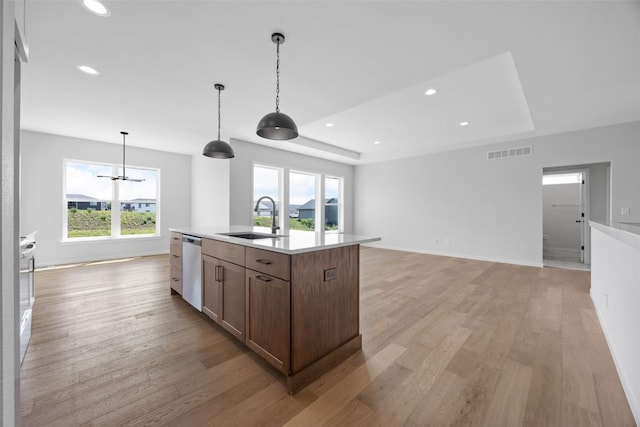 1442 Cardinal Dr, Fairfax, IA 52228 - kitchen featuring white dishwasher, light wood-style floors, a raised ceiling, light countertops, and an island with sink