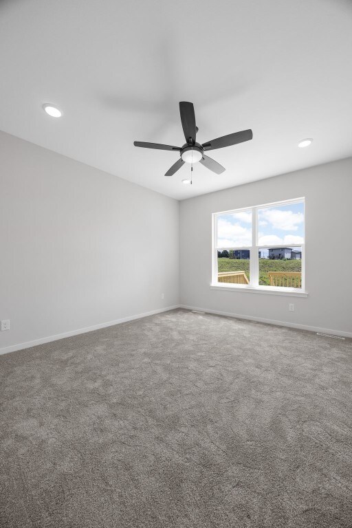 1442 Cardinal Dr, Fairfax, IA 52228 - empty room with carpet floors, ceiling fan, and recessed lighting