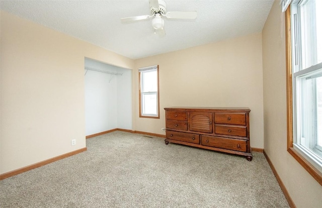 110 SE 12th St, Oelwein, IA 50662 - bedroom with carpet flooring, baseboards, a textured ceiling, and ceiling fan