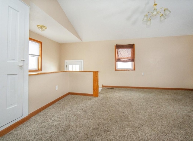 110 SE 12th St, Oelwein, IA 50662 - carpeted spare room featuring a wealth of natural light, baseboards, an inviting chandelier, and lofted ceiling