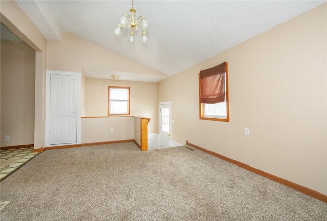 110 SE 12th St, Oelwein, IA 50662 - empty room featuring a notable chandelier, light colored carpet, baseboards, and lofted ceiling