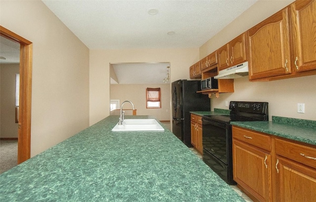110 SE 12th St, Oelwein, IA 50662 - kitchen with a sink, dark countertops, under cabinet range hood, brown cabinets, and black appliances
