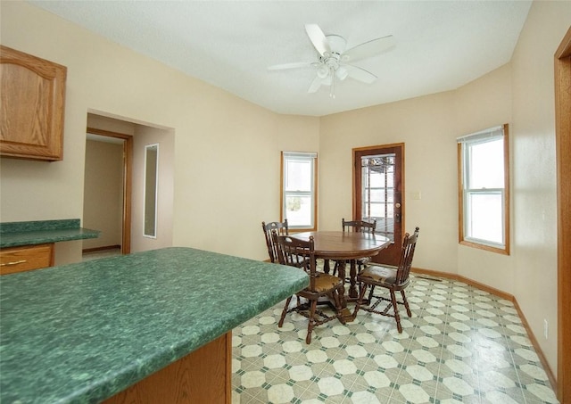 110 SE 12th St, Oelwein, IA 50662 - dining area featuring light floors, baseboards, a ceiling fan, and a wealth of natural light