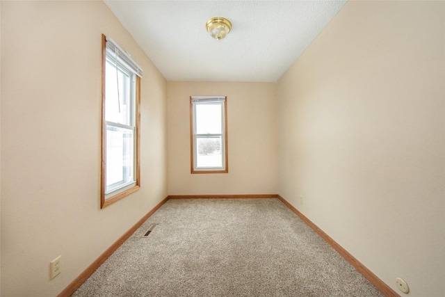 110 SE 12th St, Oelwein, IA 50662 - empty room featuring light colored carpet, baseboards, and visible vents