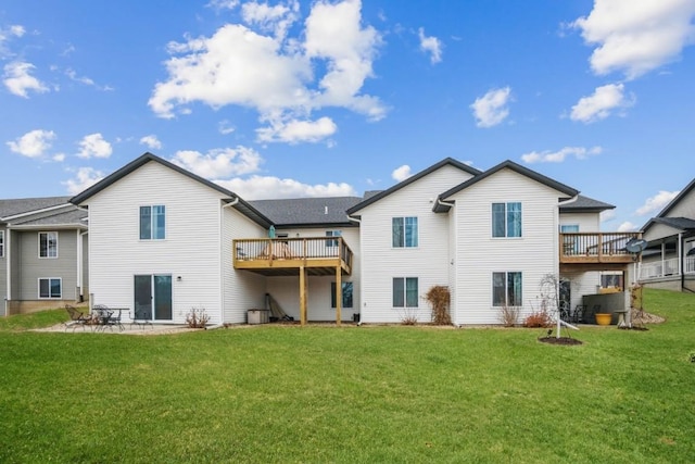 back of property with a yard and a wooden deck