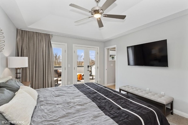 bedroom with access to outside, ceiling fan, a tray ceiling, french doors, and baseboards