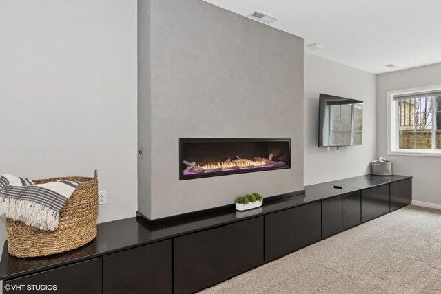 carpeted living room with visible vents and baseboards