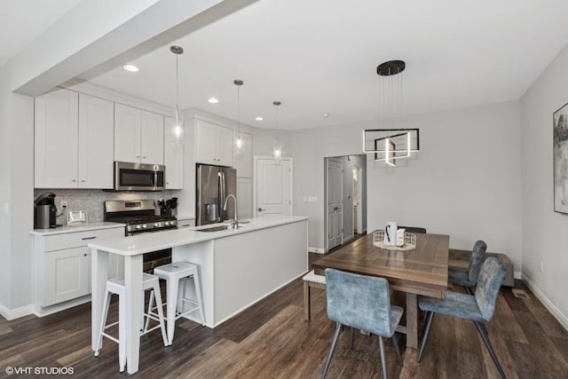 dining area featuring recessed lighting, baseboards, and dark wood finished floors