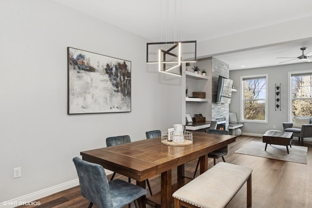 dining area featuring baseboards, a ceiling fan, and wood finished floors