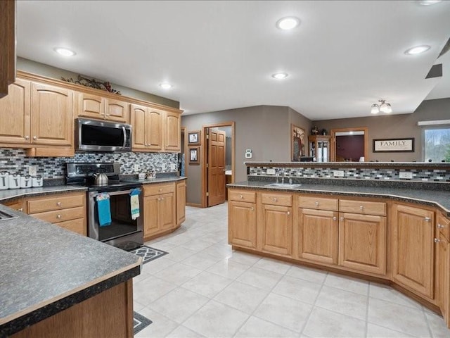 3752 Lacina Dr SW, Iowa City, IA 52240 - kitchen with light tile patterned flooring, appliances with stainless steel finishes, decorative backsplash, and dark countertops