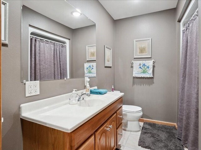 3752 Lacina Dr SW, Iowa City, IA 52240 - bathroom featuring tile patterned floors, toilet, vanity, and baseboards