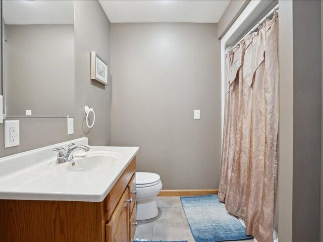 3752 Lacina Dr SW, Iowa City, IA 52240 - bathroom with vanity, baseboards, curtained shower, tile patterned floors, and toilet