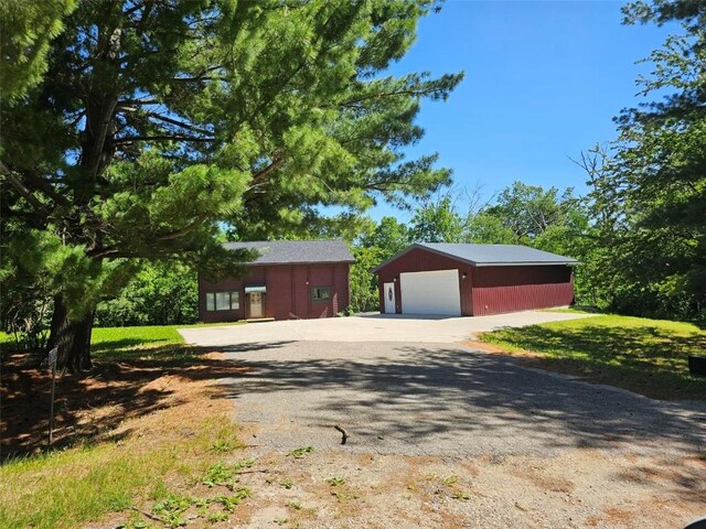 view of front of home featuring a garage, an outdoor structure, and driveway
