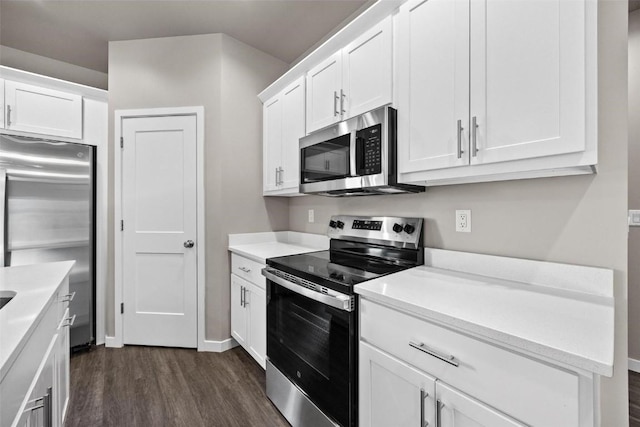 2068 Whispering Meadow Dr, Iowa City, IA 52240 - kitchen with white cabinets, light countertops, dark wood finished floors, and stainless steel appliances