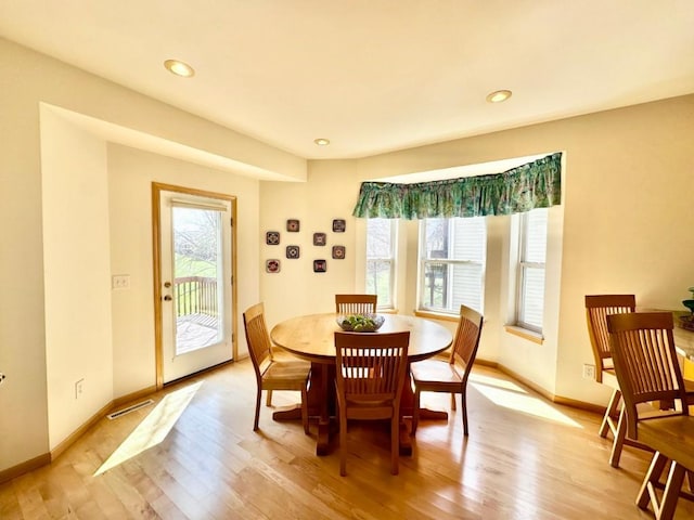 dining area with baseboards, light wood finished floors, and recessed lighting