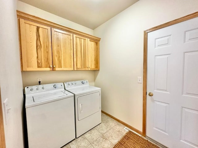clothes washing area with light tile patterned floors, baseboards, cabinet space, and washer and clothes dryer