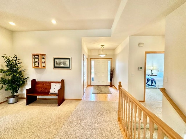 entryway with baseboards, recessed lighting, and carpet