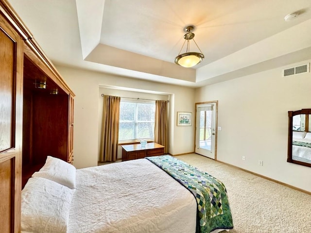 bedroom featuring visible vents, baseboards, a tray ceiling, access to exterior, and light colored carpet