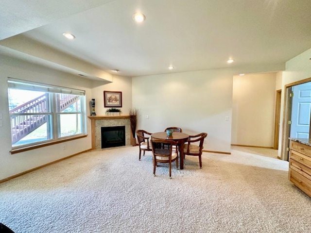 dining area featuring recessed lighting, a fireplace, light colored carpet, and baseboards
