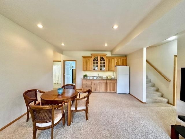 dining room featuring baseboards, recessed lighting, light carpet, and stairs