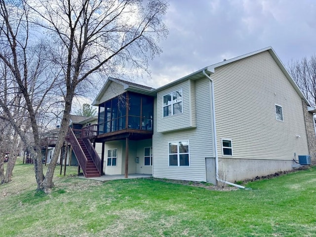 rear view of house featuring a sunroom, a patio area, a lawn, stairway, and cooling unit