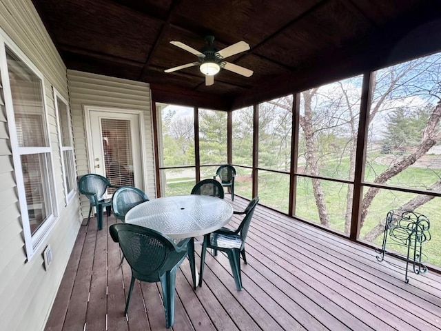 sunroom / solarium with a wealth of natural light, a ceiling fan, and outdoor dining space