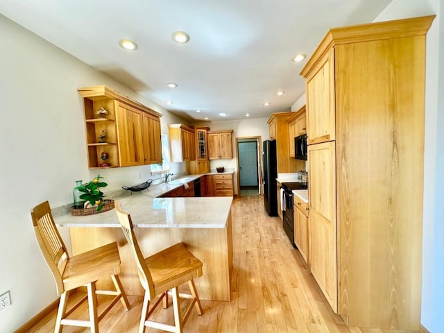 kitchen featuring open shelves, light countertops, light wood-style floors, a peninsula, and black appliances
