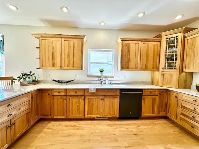 kitchen featuring glass insert cabinets, light countertops, light wood finished floors, and dishwashing machine
