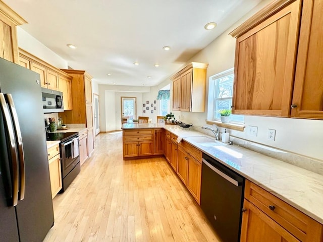 kitchen with a sink, plenty of natural light, a peninsula, and stainless steel appliances