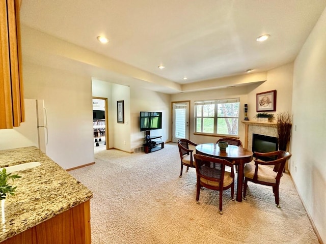 dining area with light colored carpet, a fireplace, baseboards, and recessed lighting