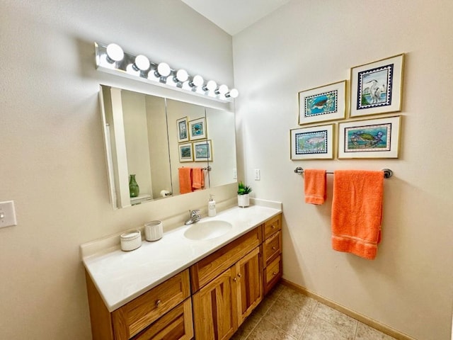 bathroom with vanity, baseboards, and tile patterned flooring