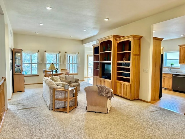 living area featuring light carpet, recessed lighting, and baseboards