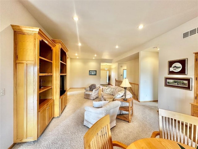 living area with visible vents, baseboards, recessed lighting, and light colored carpet