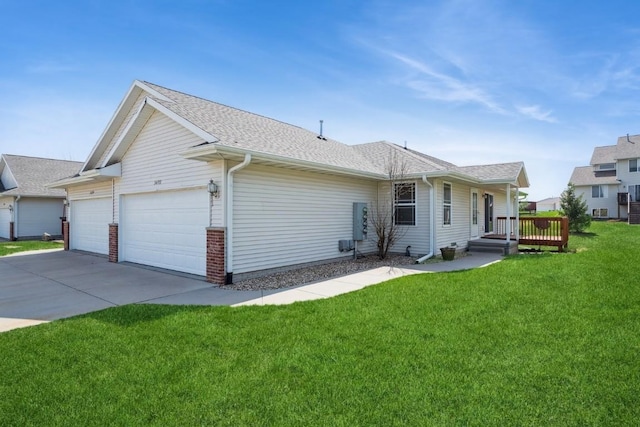 back of house with a garage, a shingled roof, a yard, and driveway