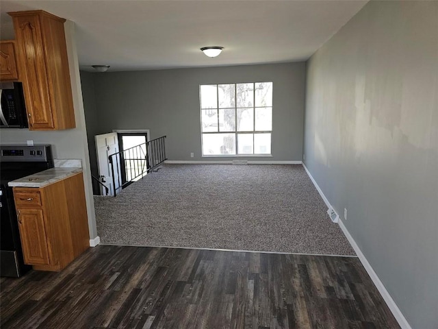 1025 Pawnee Dr NW, Cedar Rapids, IA 52405 - kitchen with stainless steel electric range, black microwave, brown cabinetry, baseboards, and light countertops