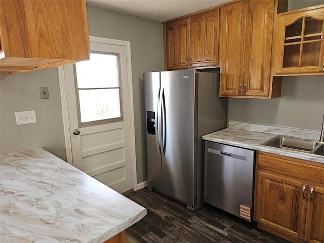 1025 Pawnee Dr NW, Cedar Rapids, IA 52405 - kitchen with stainless steel appliances, dark wood-style floors, light countertops, a sink, and glass insert cabinets