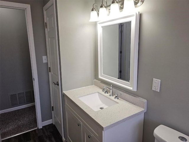 1025 Pawnee Dr NW, Cedar Rapids, IA 52405 - half bathroom with wood finished floors, toilet, and vanity