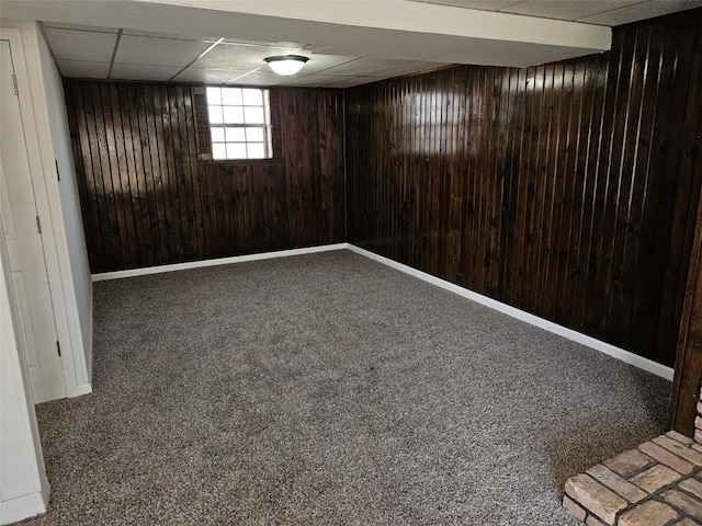 1025 Pawnee Dr NW, Cedar Rapids, IA 52405 - basement featuring wood walls, a paneled ceiling, carpet flooring, and baseboards