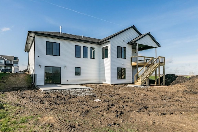 rear view of house featuring stairs, a patio area, and a wooden deck