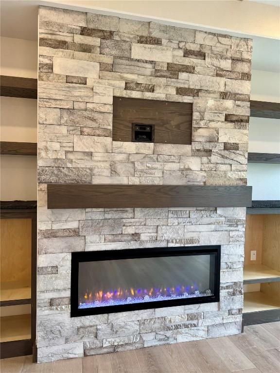 room details with a glass covered fireplace and wood finished floors