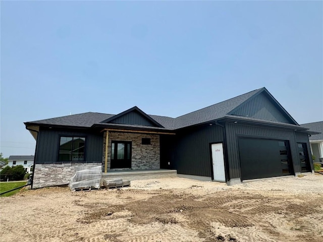 4018 Peridot Dr, Marion, IA 52302 - view of front of home featuring a garage, stone siding, driveway, a shingled roof, and covered porch